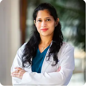 Smiling dentist, Dr. Sakshi Goyal Goyal, in a professional setting.