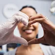 A concerned patient being warmly greeted at a dental office front desk by a reassuring staff member, suggesting prompt, caring attention in an urgent situation.