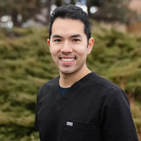 Headshot of Dr. Greg M. Lee, DMD, smiling in professional attire.
