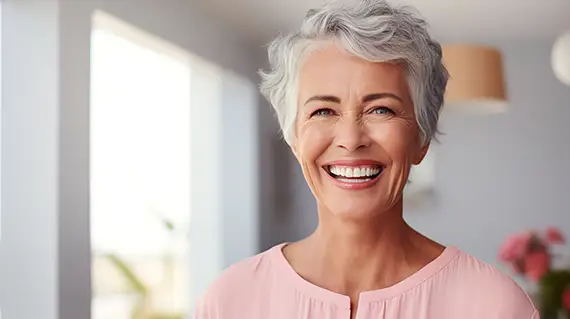 Smiling woman showcasing her dental implants.