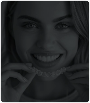A close-up of a patient smiling confidently, showing a natural-looking implant restoration that blends seamlessly with surrounding teeth. The image conveys precision craftsmanship and a life-changing outcome.