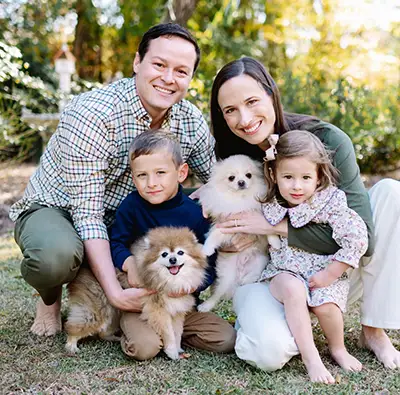 Dr. Bobby Davis smiling with his family outdoors.